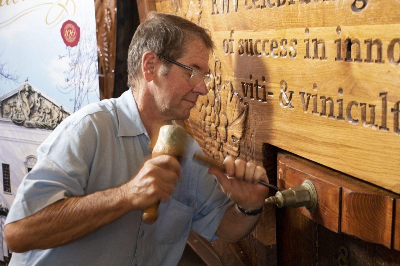 Woodcarving artist Ivan Hunter adds the final touches to the newly unveiled Centenary vat in Cathedral Cellar