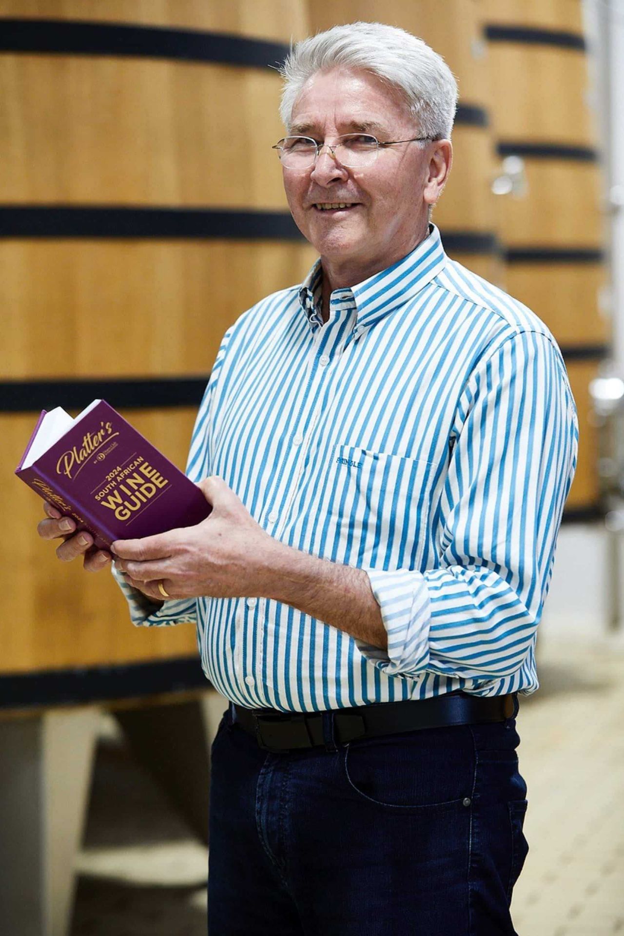 Platters editor Philip van Zyl holding the 2024 Platters SA Wine Guide