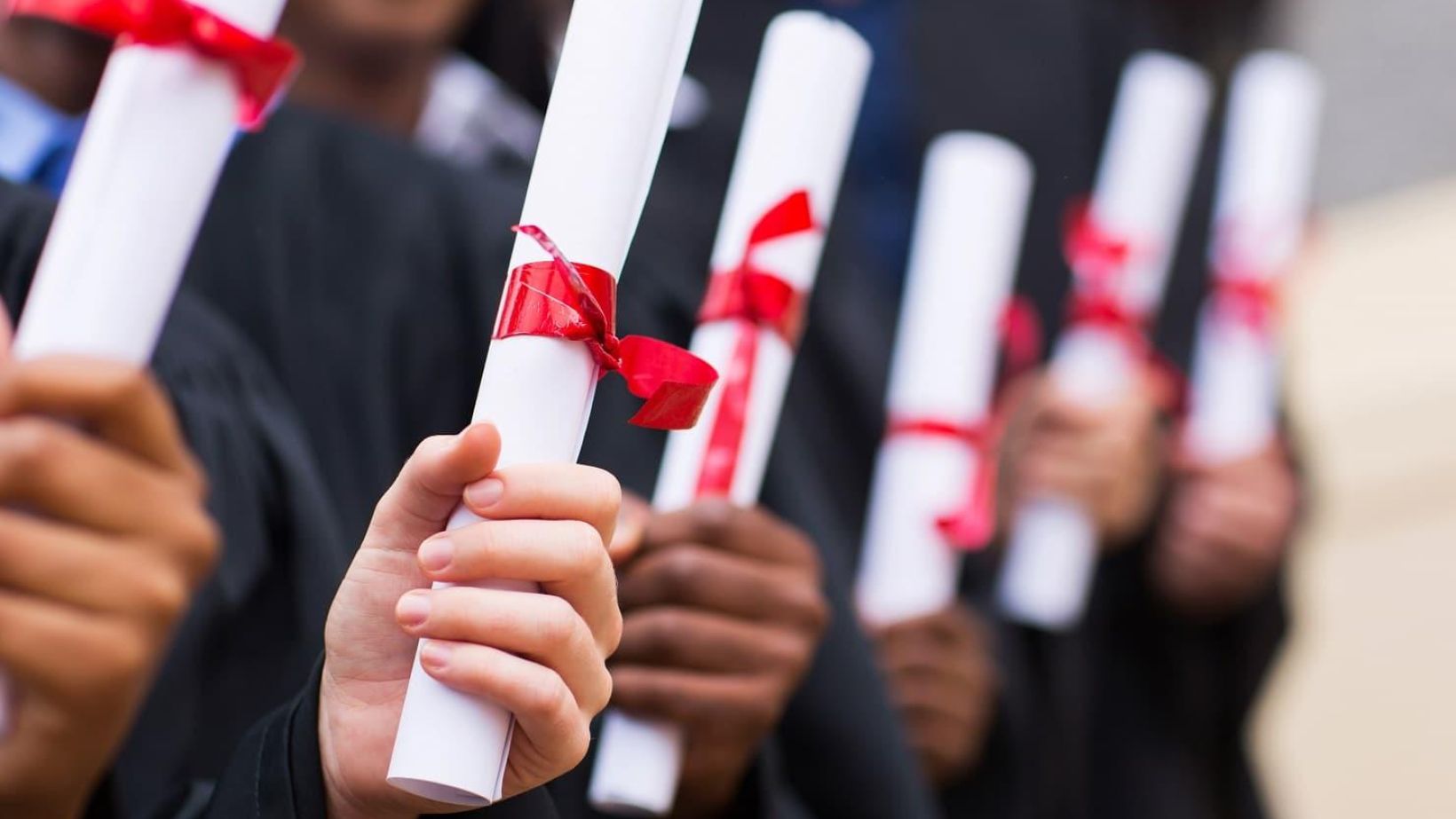 group of multiracial graduates holding diploma