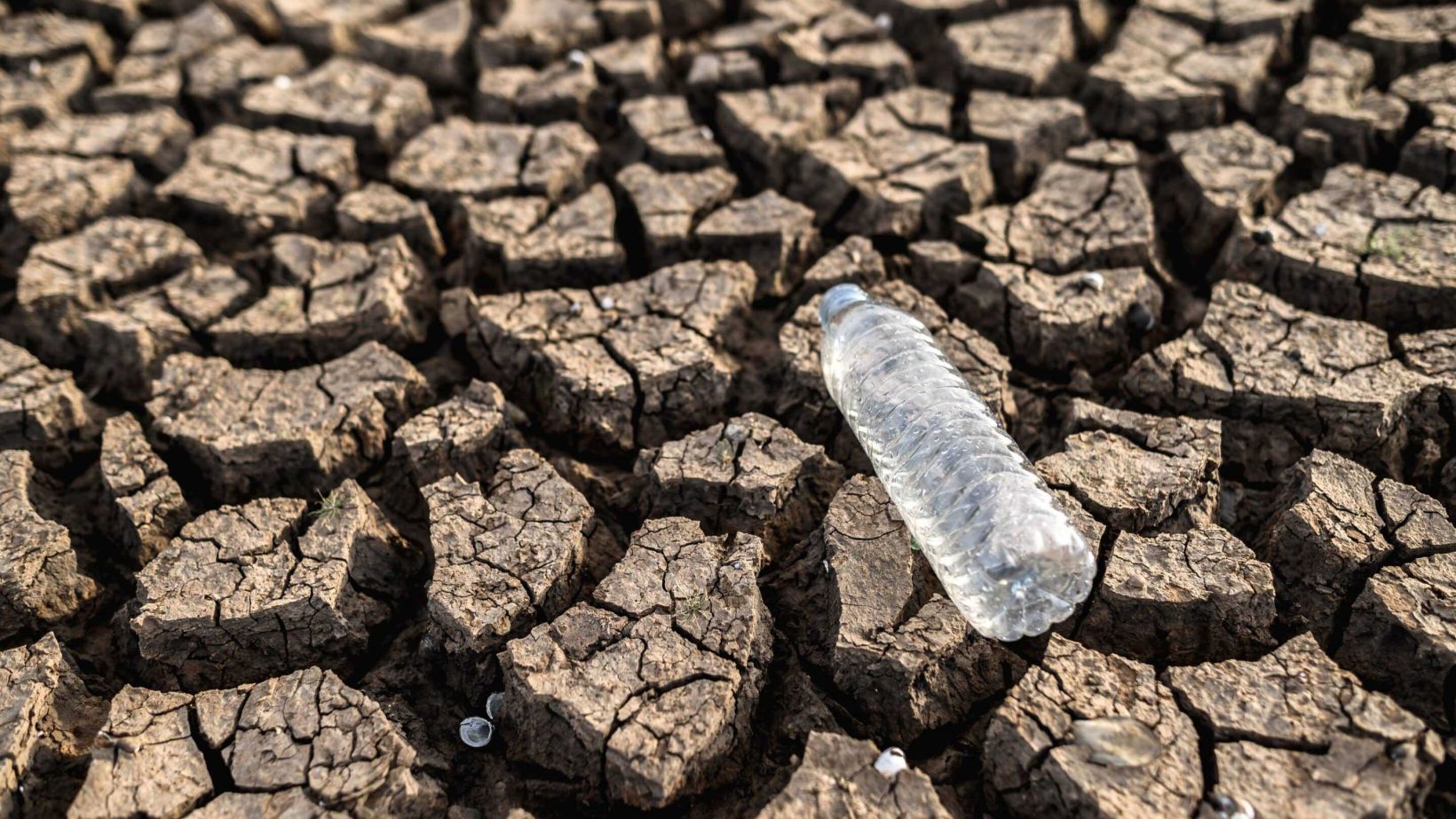 Water bottles dry soil with dry cracked soil global warming