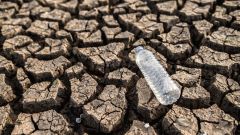 Water bottles dry soil with dry cracked soil global warming